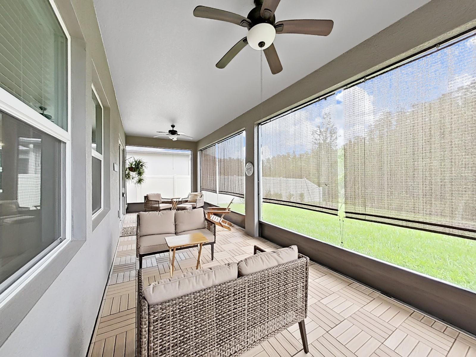 Patio with Upgraded flooring, fans and blinds.