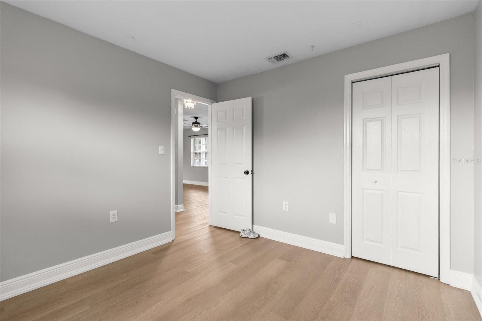 Neutral tones, wood-look floors, and a double closet make this space cozy, functional, and easy to personalize
