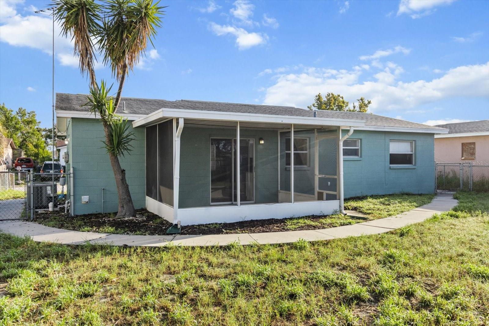The walkway creates a natural flow through the yard, perfect for pets, play, or simply enjoying the Florida breeze.