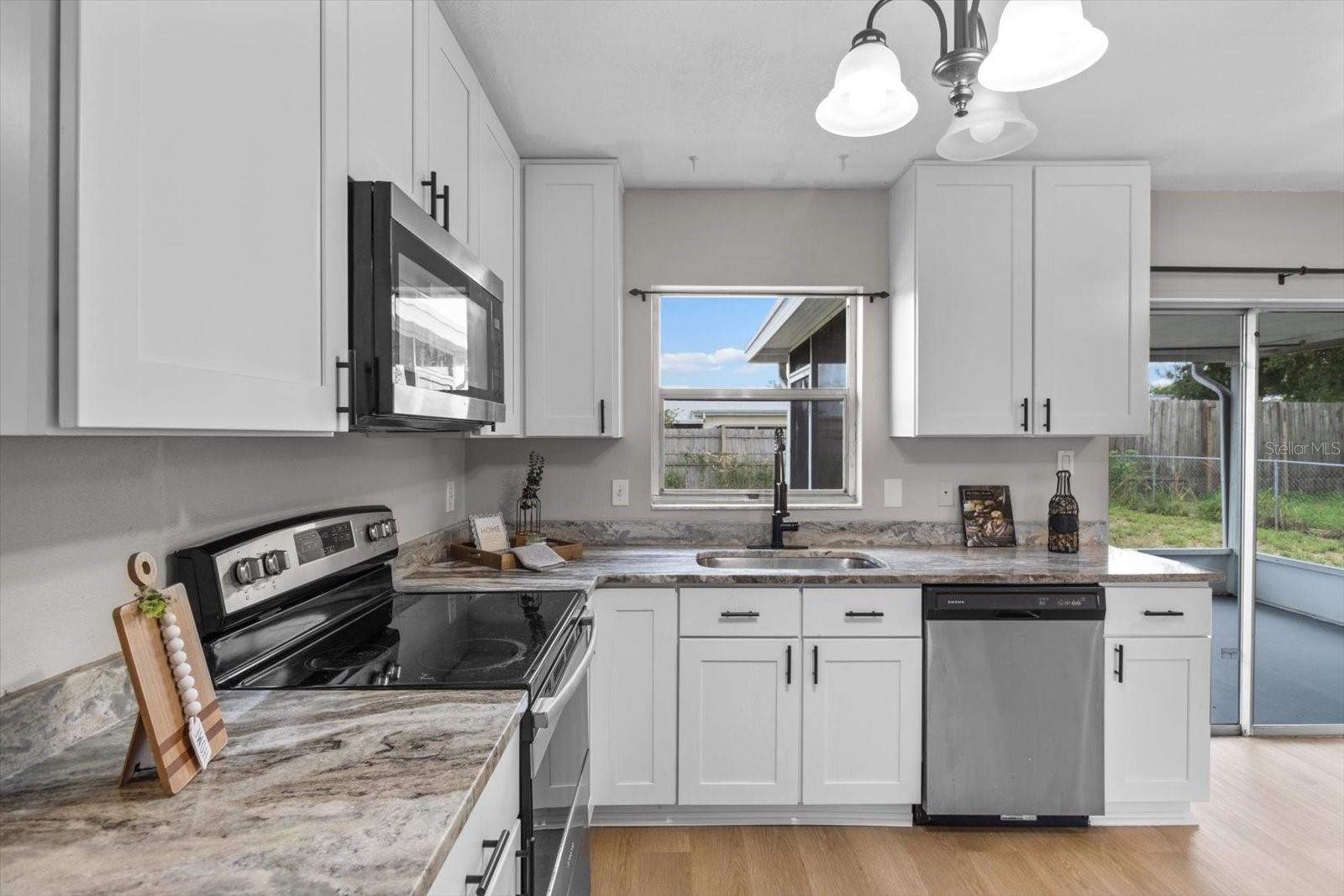 Enjoy views of the backyard right from your sink in this thoughtfully designed kitchen with access to the screened porch, perfect for entertaining inside and out.