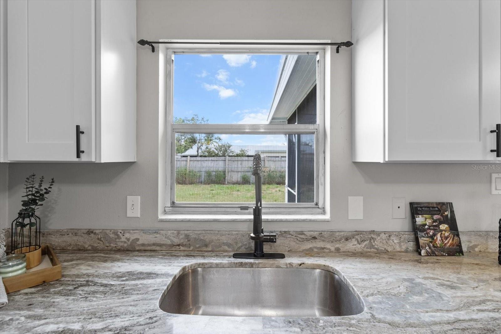 Window above the sink with a view of the backyard—perfect for multitasking while you cook.