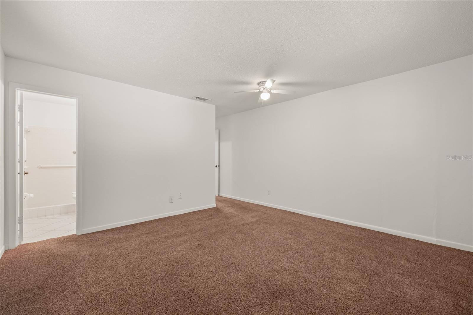 Primary bedroom leading into bathroom