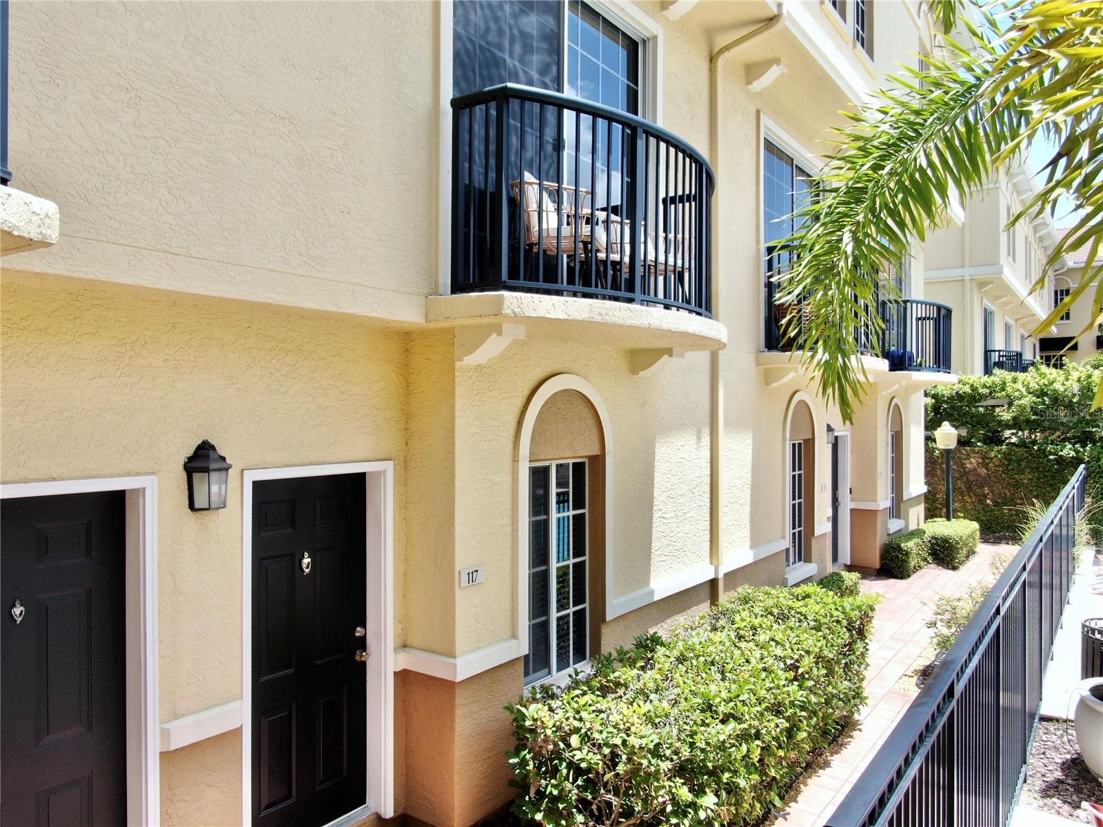 Front Door facing pool area, balcony on second floor