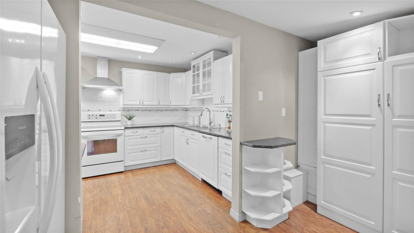 More kitchen space with cabinets and pantry area