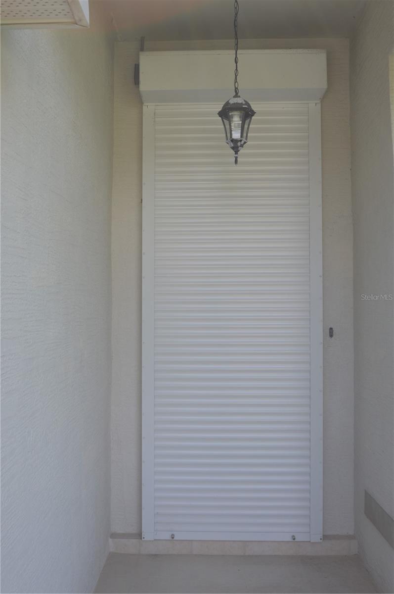 Electrically operated hurricane rolling shutters on front door.