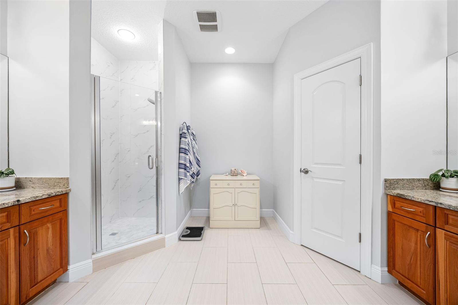 Primary bathroom with double vanities and a private commode