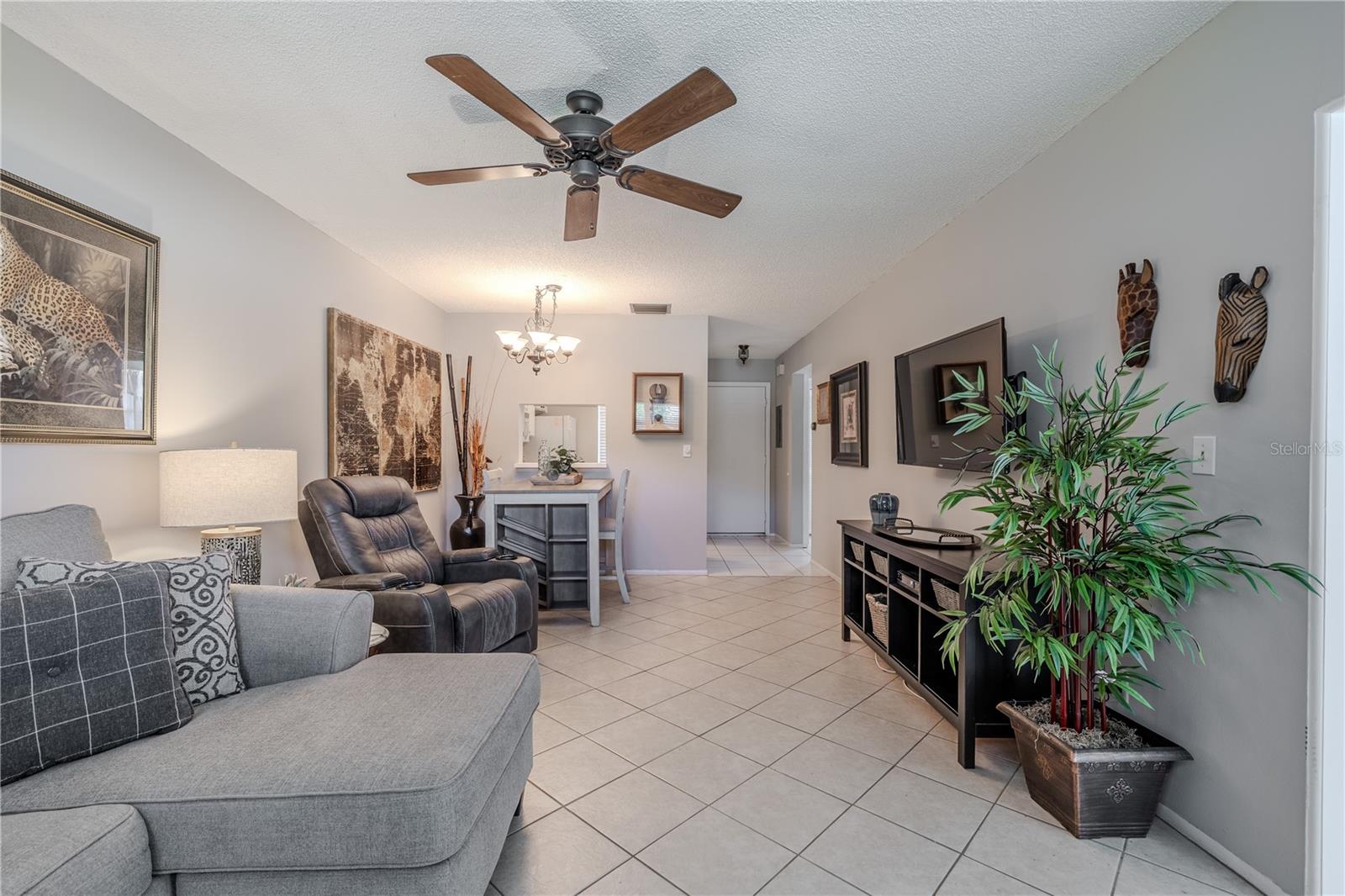 With a seamless flow between living and dining areas, the dining area features a modern light fixture and a stylish wall cutout to the kitchen, perfect for casual dining or entertaining.