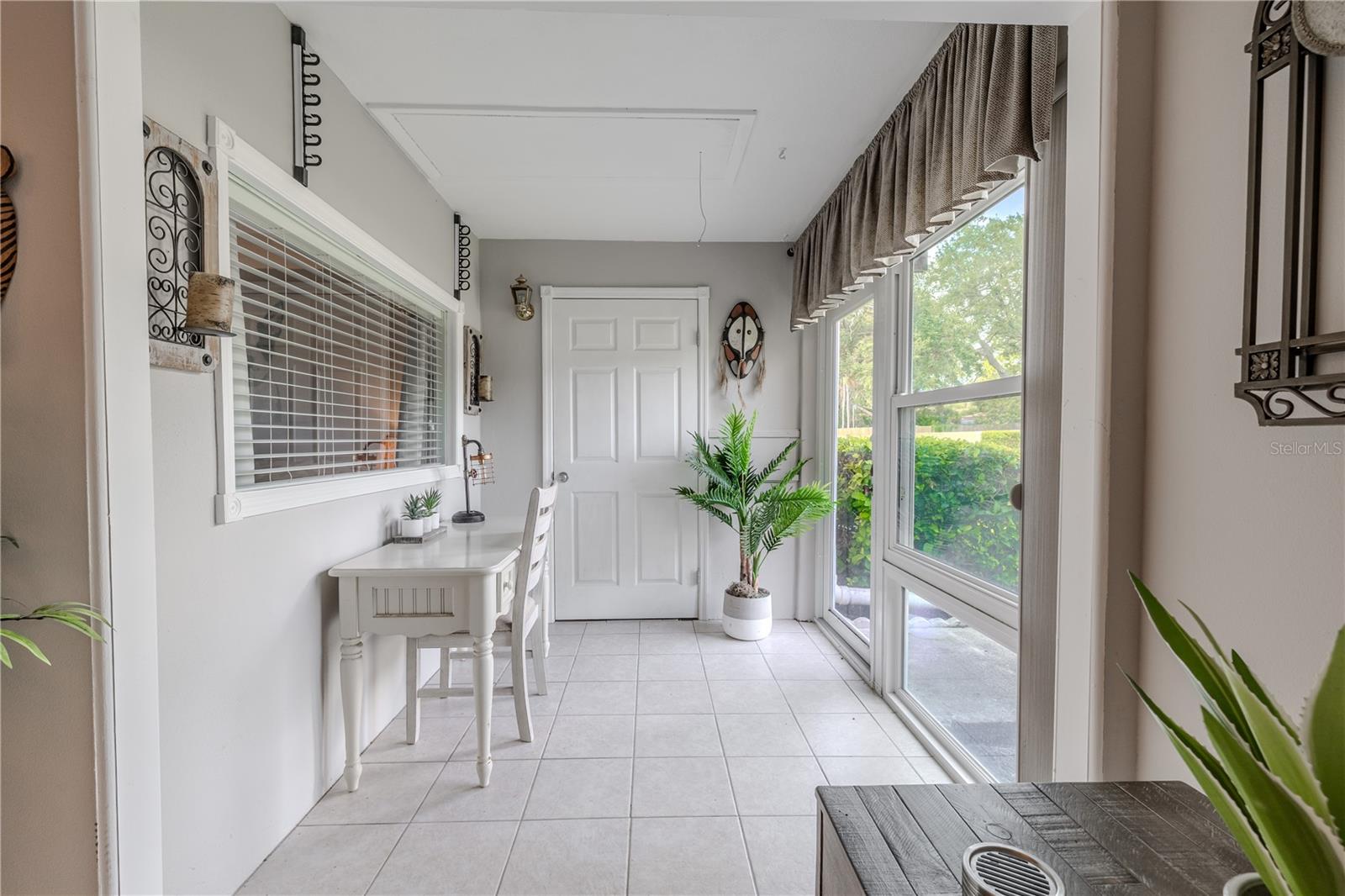 The inviting Florida room is a bright and versatile bonus space, perfect for a home office, reading nook, or hobby area. Large windows flood the room with natural light while offering serene views of the lush greenery outside.