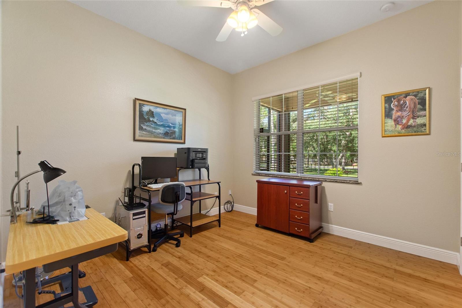 Bedroom 2 with ceiling fan and bamboo flooring.