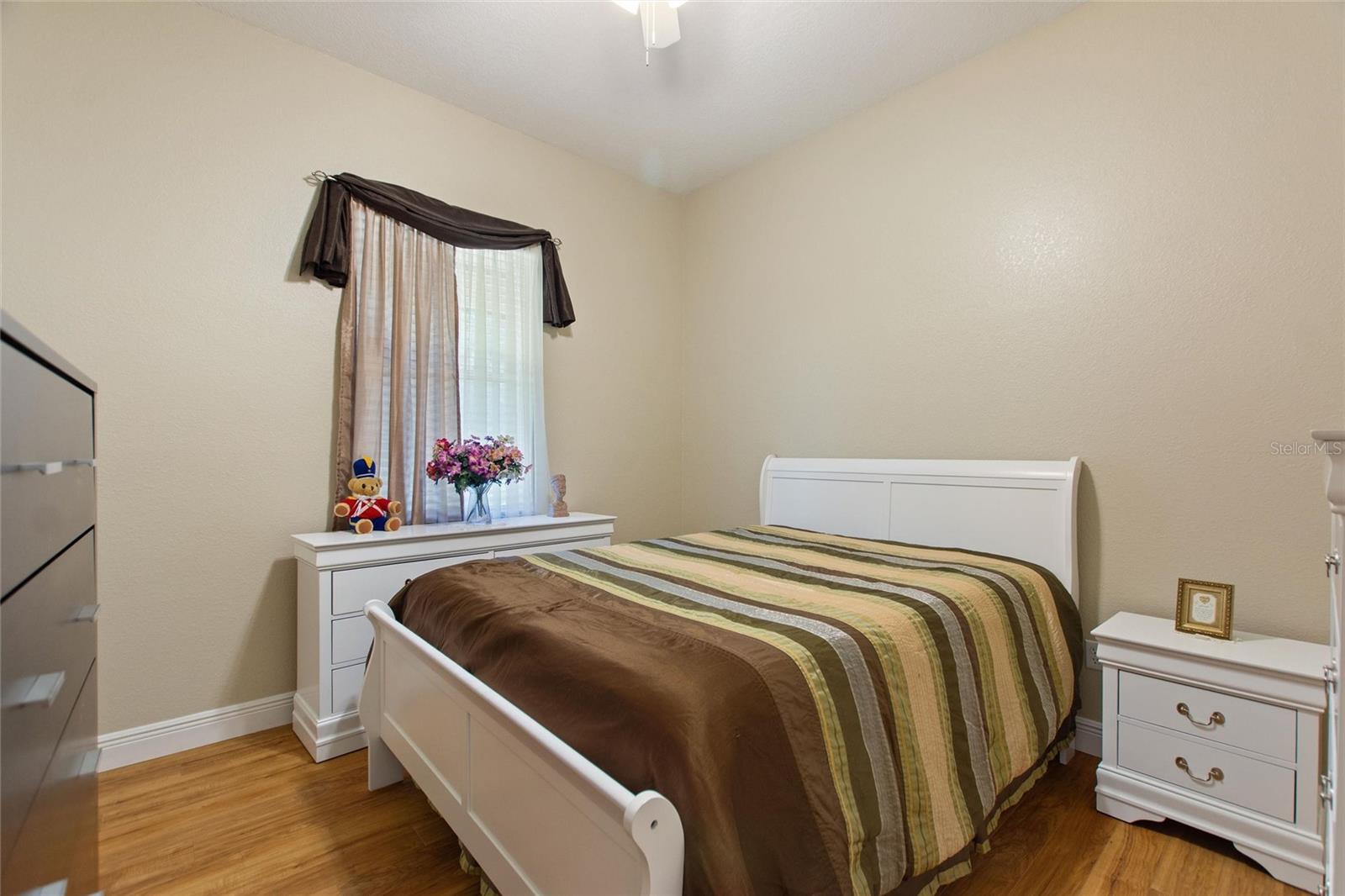 Bedroom 3 with wood laminate flooring and ceiling fan.