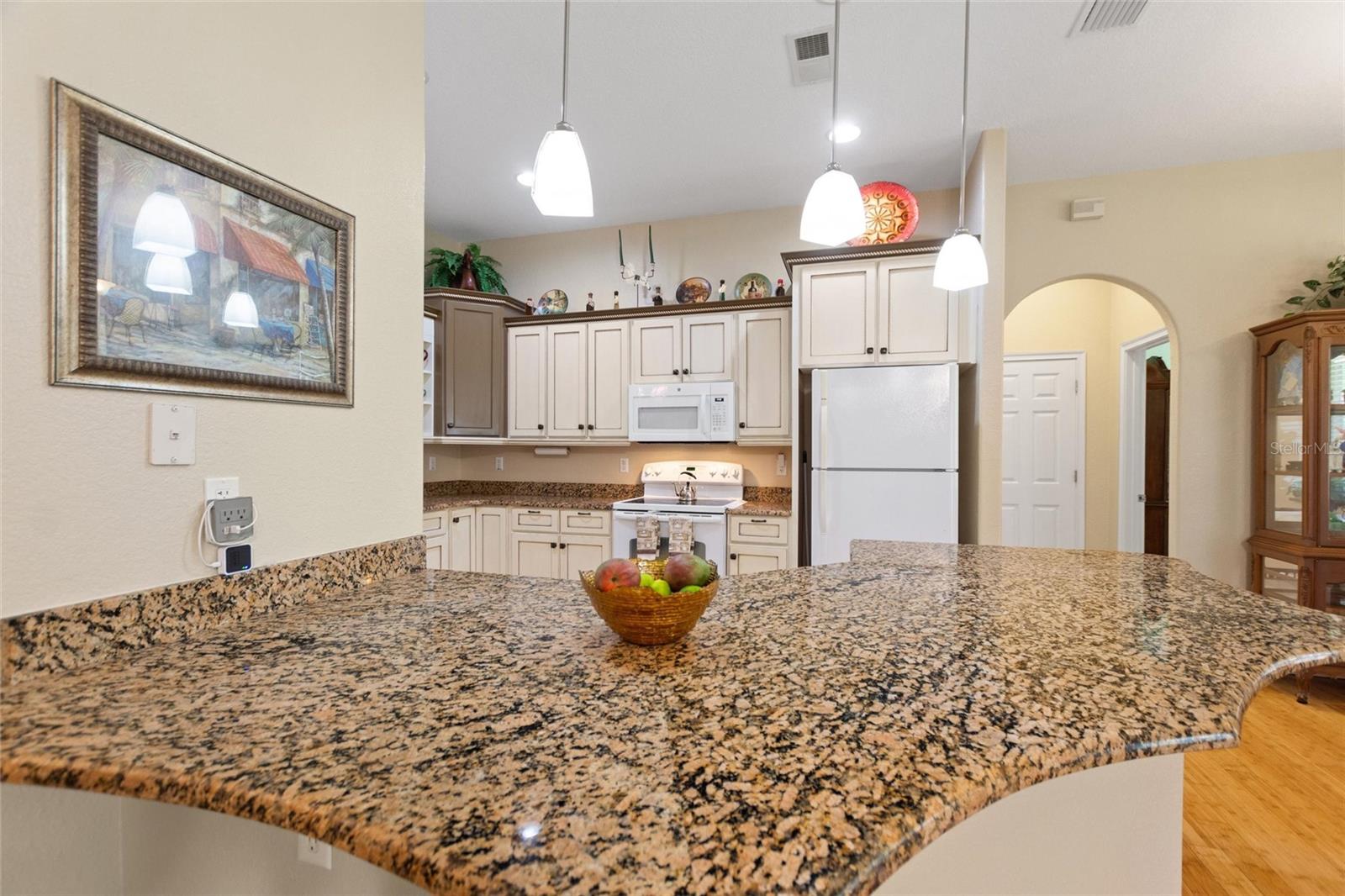 Kitchen features granite counter tops and pendant lighting.