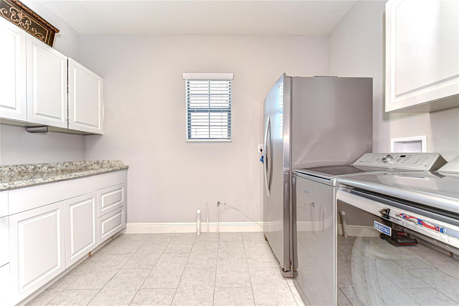 Upstairs laundry room with storage and fridge!