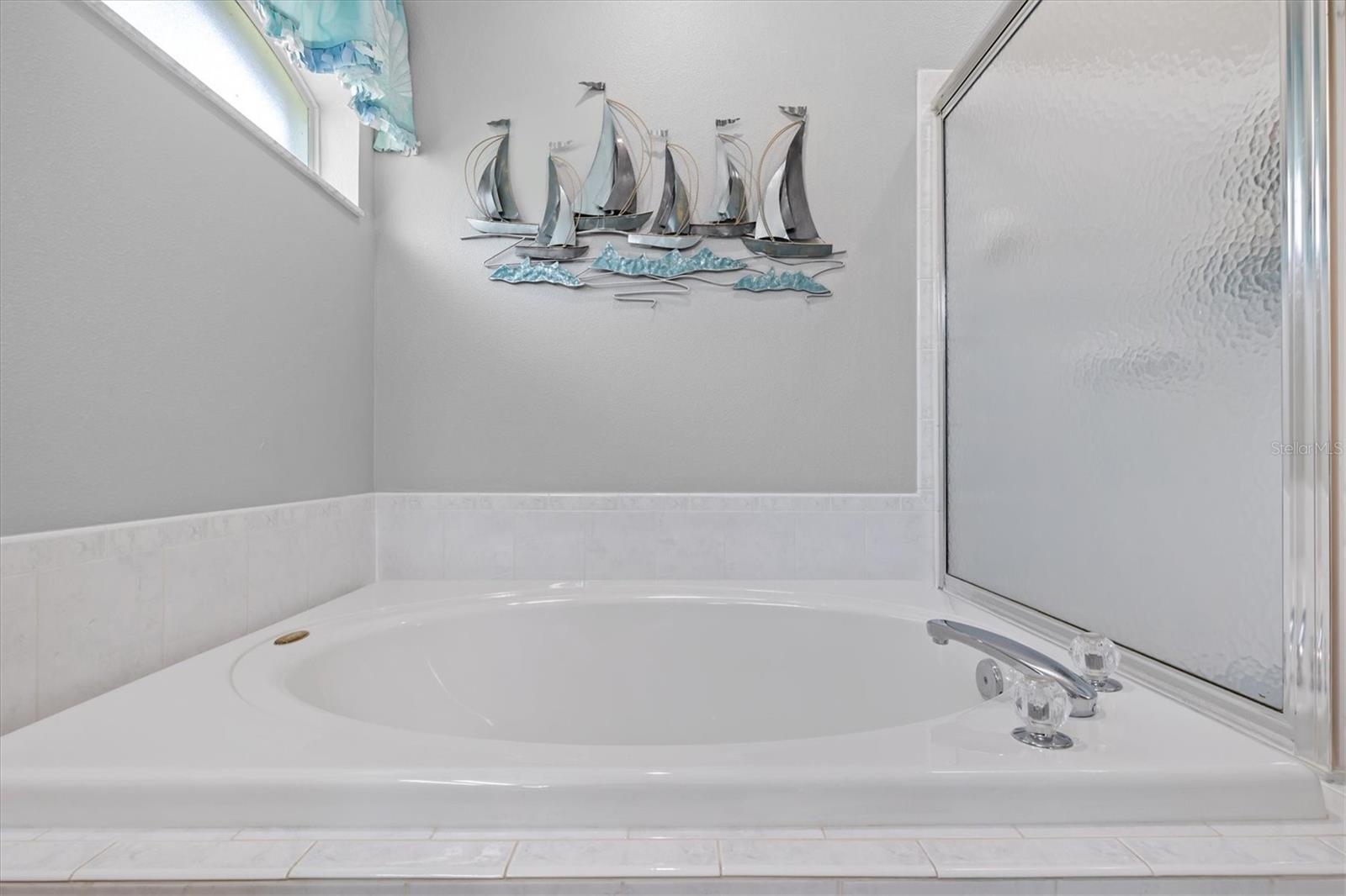 soaking tub and glass enclosed shower