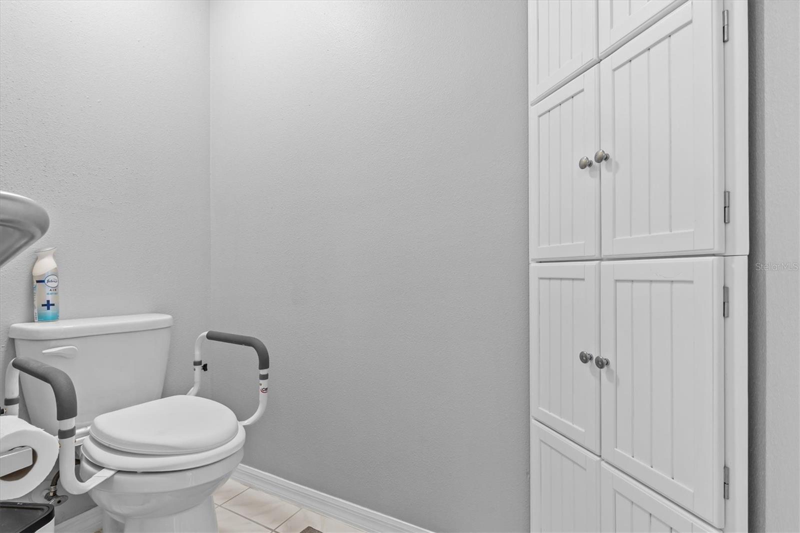 Water closet with corner linen cabinet