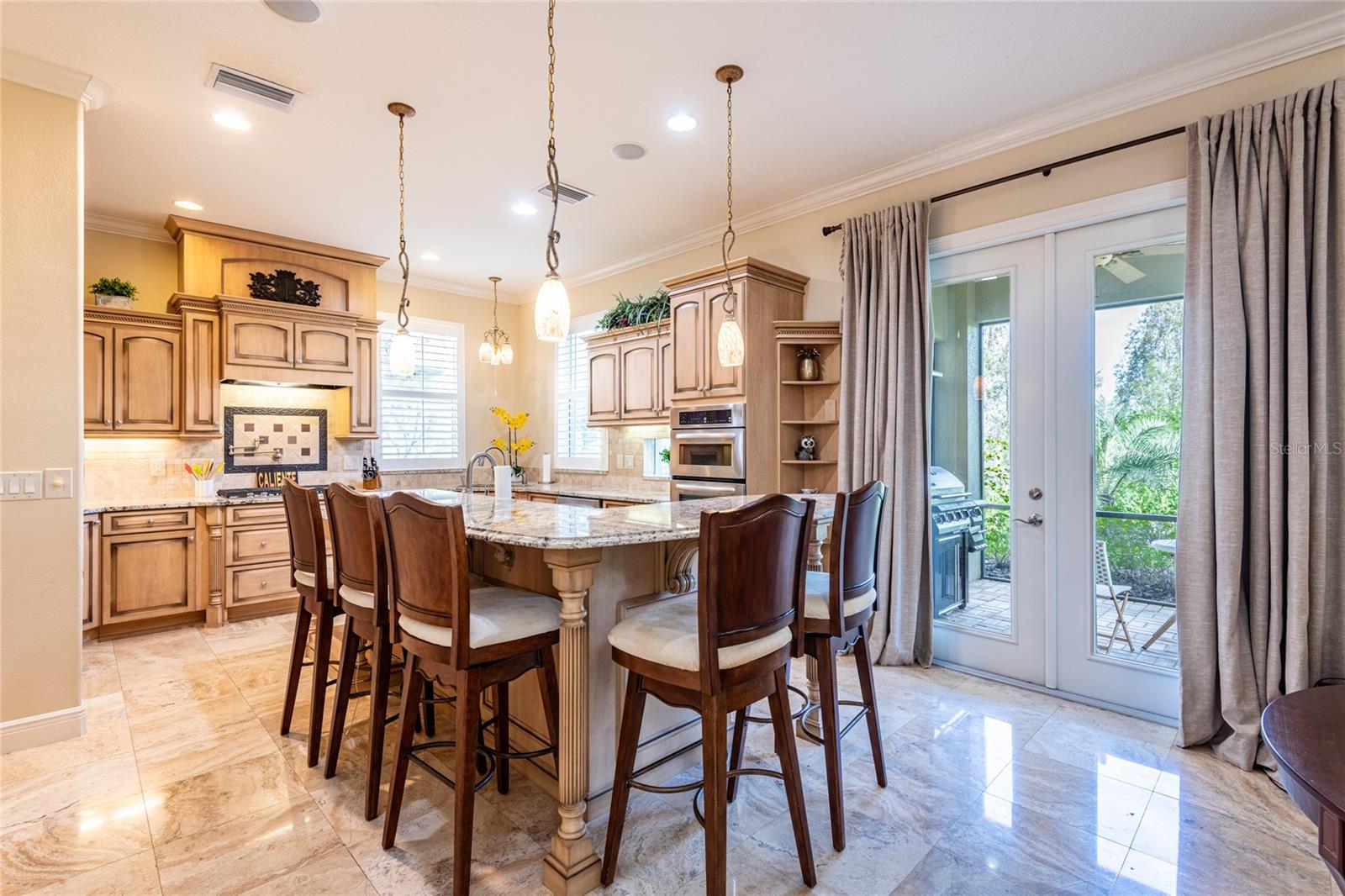 Super functional and upgraded kitchen with breakfast bar that seats 5. French doors lead to covered lanai and hot tub.