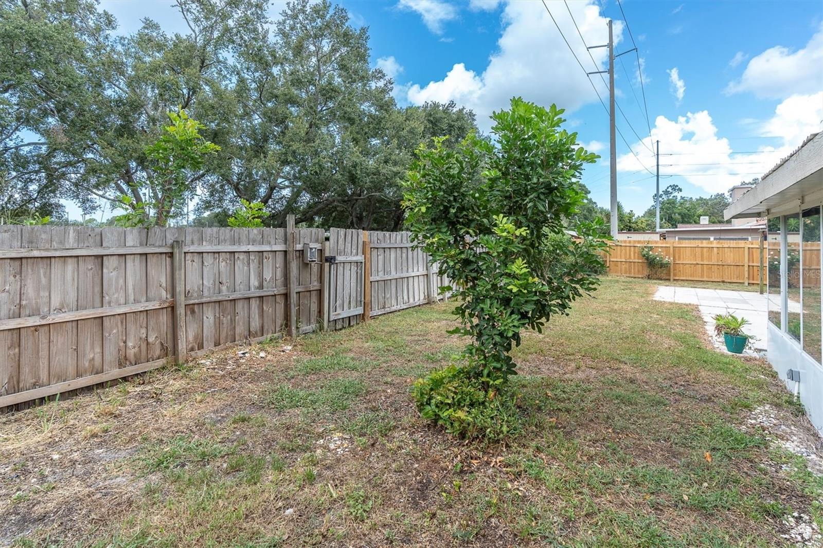View of fenced back yard and gate leading to Pinellas Trail