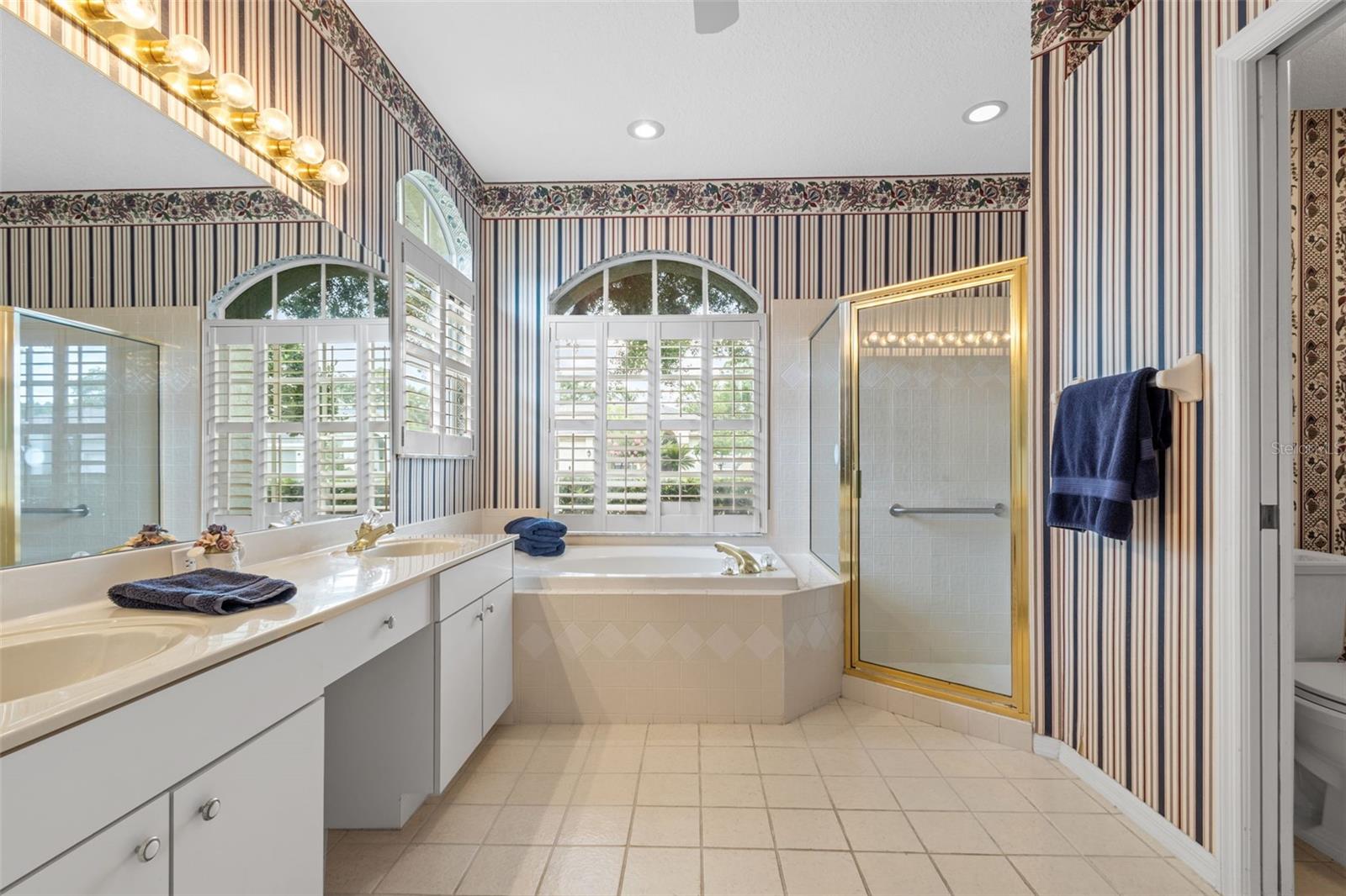 En suite primary bathroom with soaking tub, double vanity, and walk-in shower
