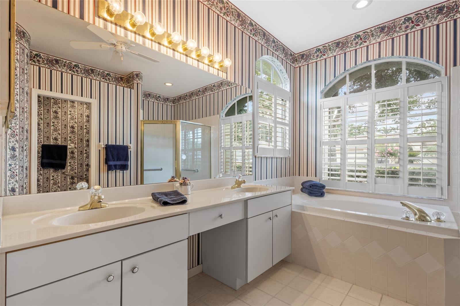 En suite primary bathroom with soaking tub, double vanity, and walk-in shower