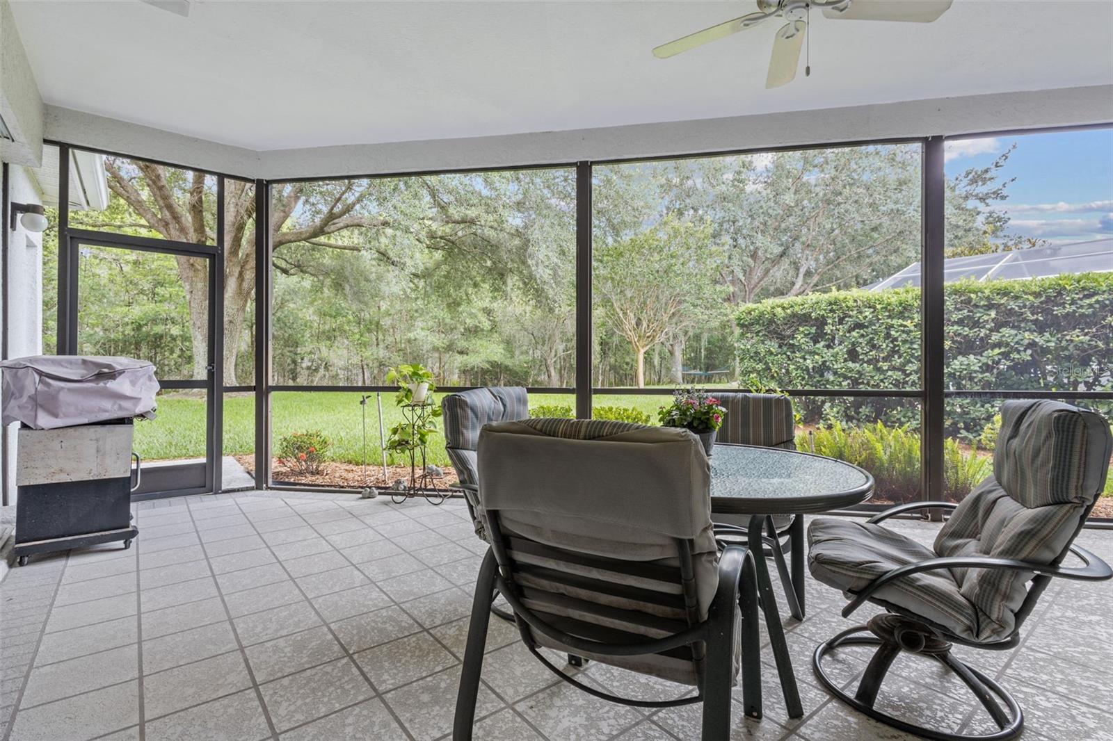 Screened-in patio perfect for relaxing or entertaining—overlooking the private backyard and conservation.