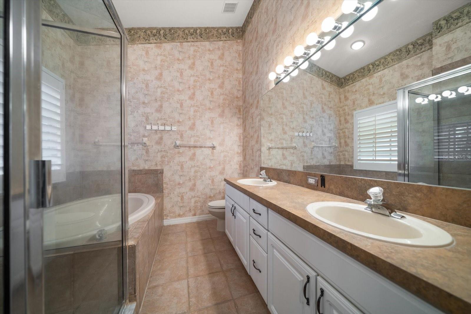 Ensuite primary bathroom with tub and shower