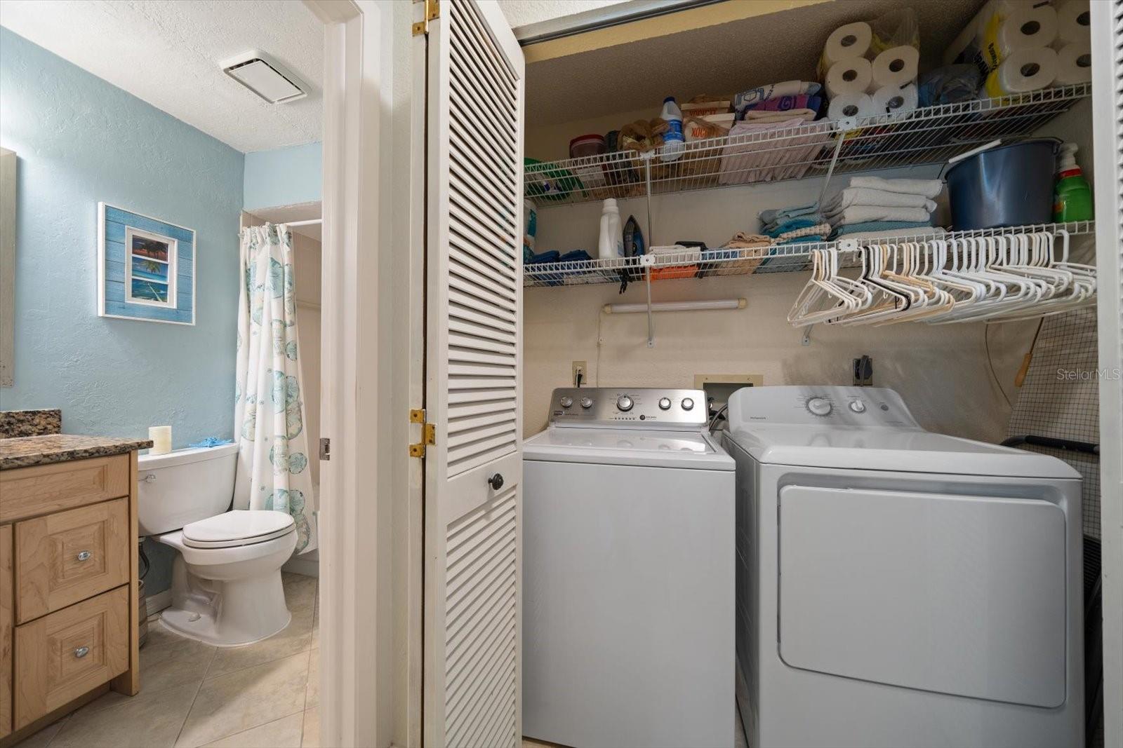Inside laundry closet with newer washer and dryer