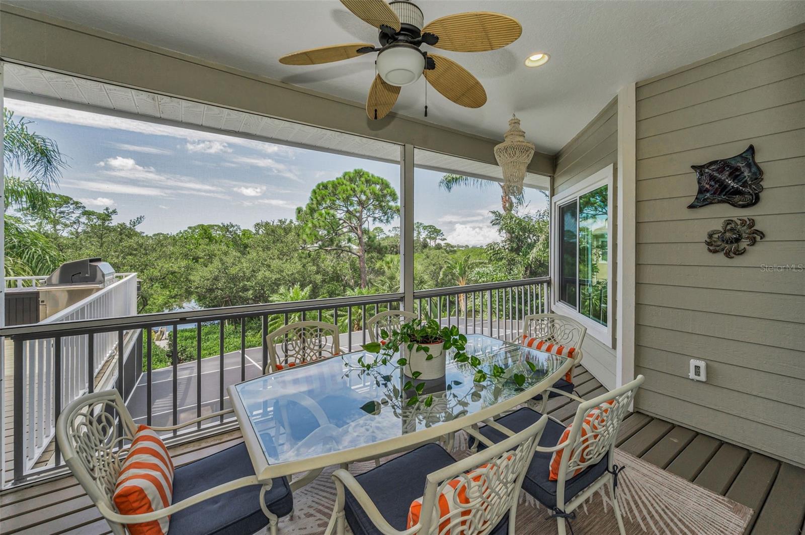 Screened-in porch with ceiling fan and water view