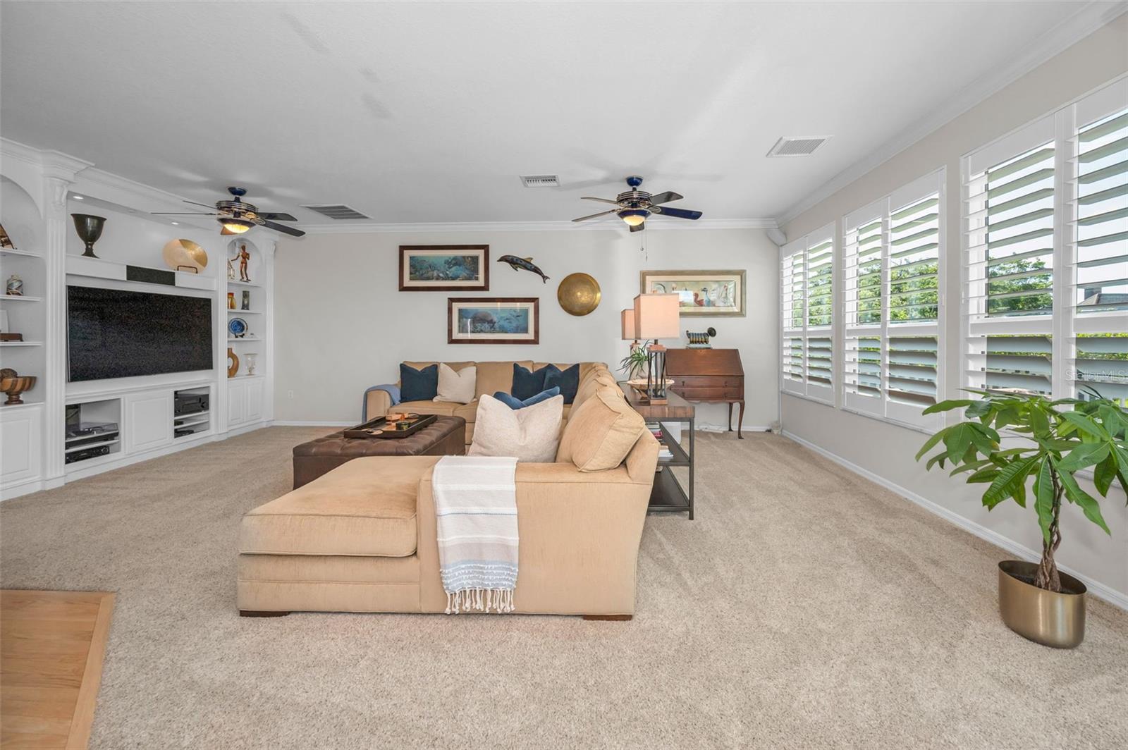 Family Room with custom built-in shelving and wood shutters
