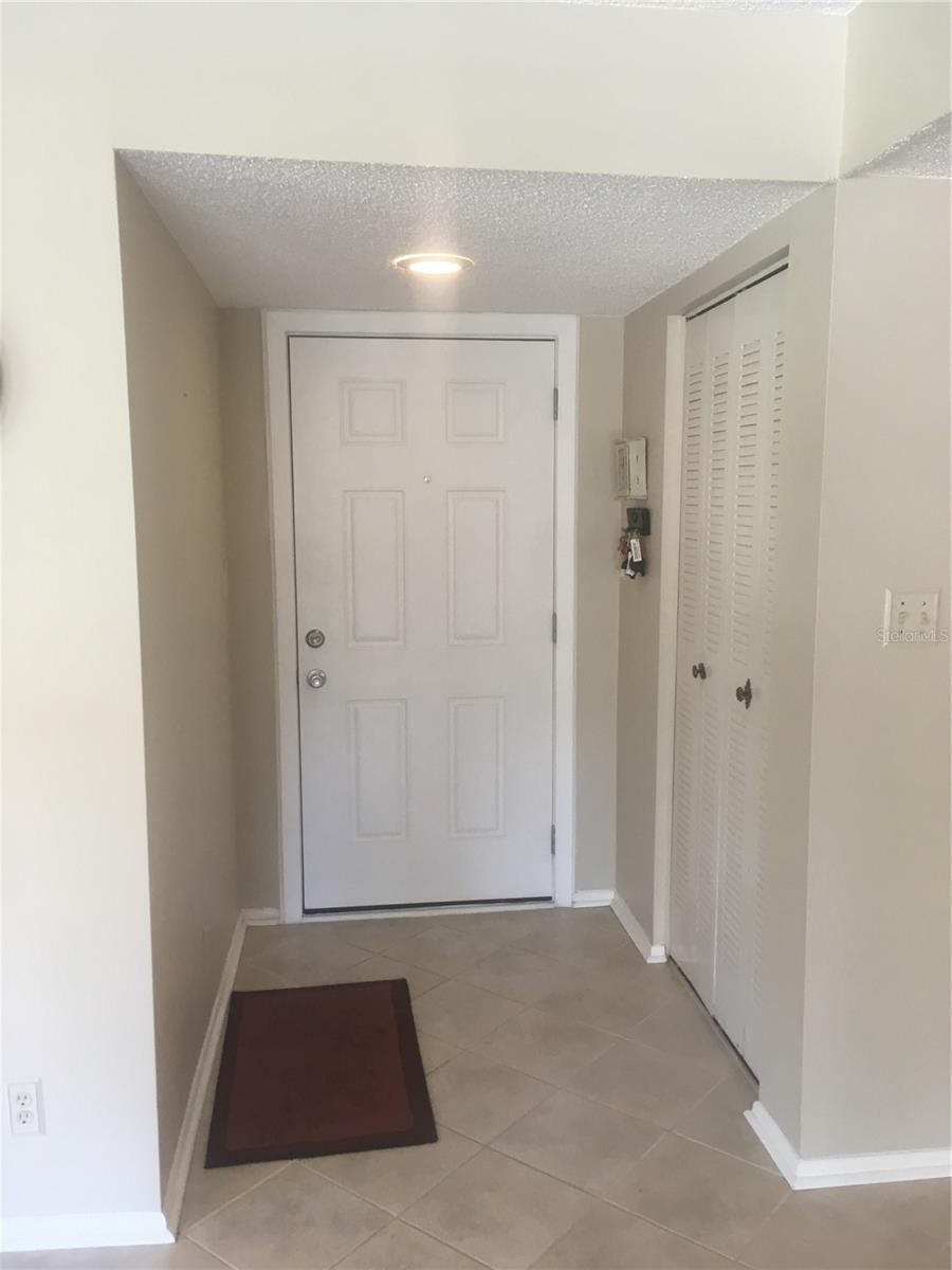front door and interior foyer with coat closet
