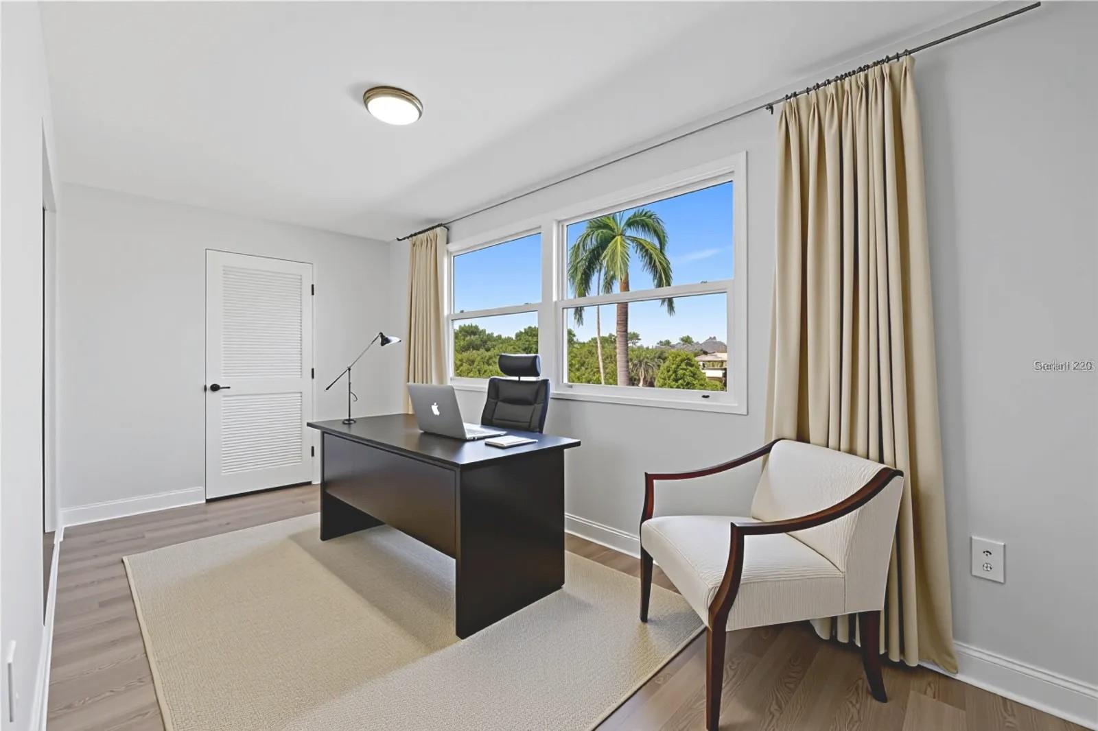 Enclosed sunroom virtually stage as a office.