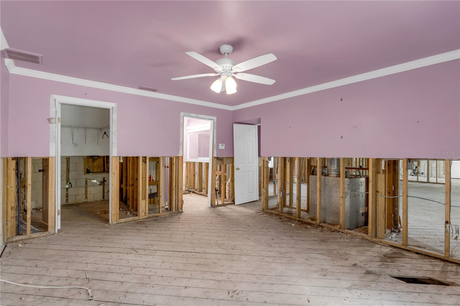 This primary suite is complete with a large walk-in closet and French doors that lead to the screened in lanai.