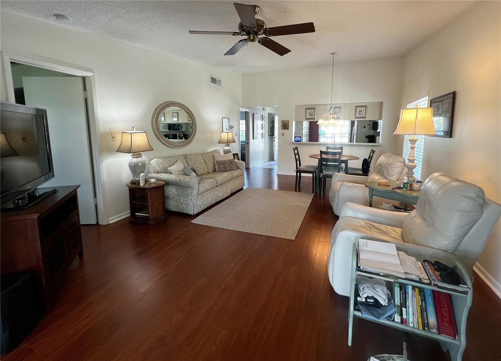 View of the living room looking towards the front of the condo. The primary suite is the door to the left.