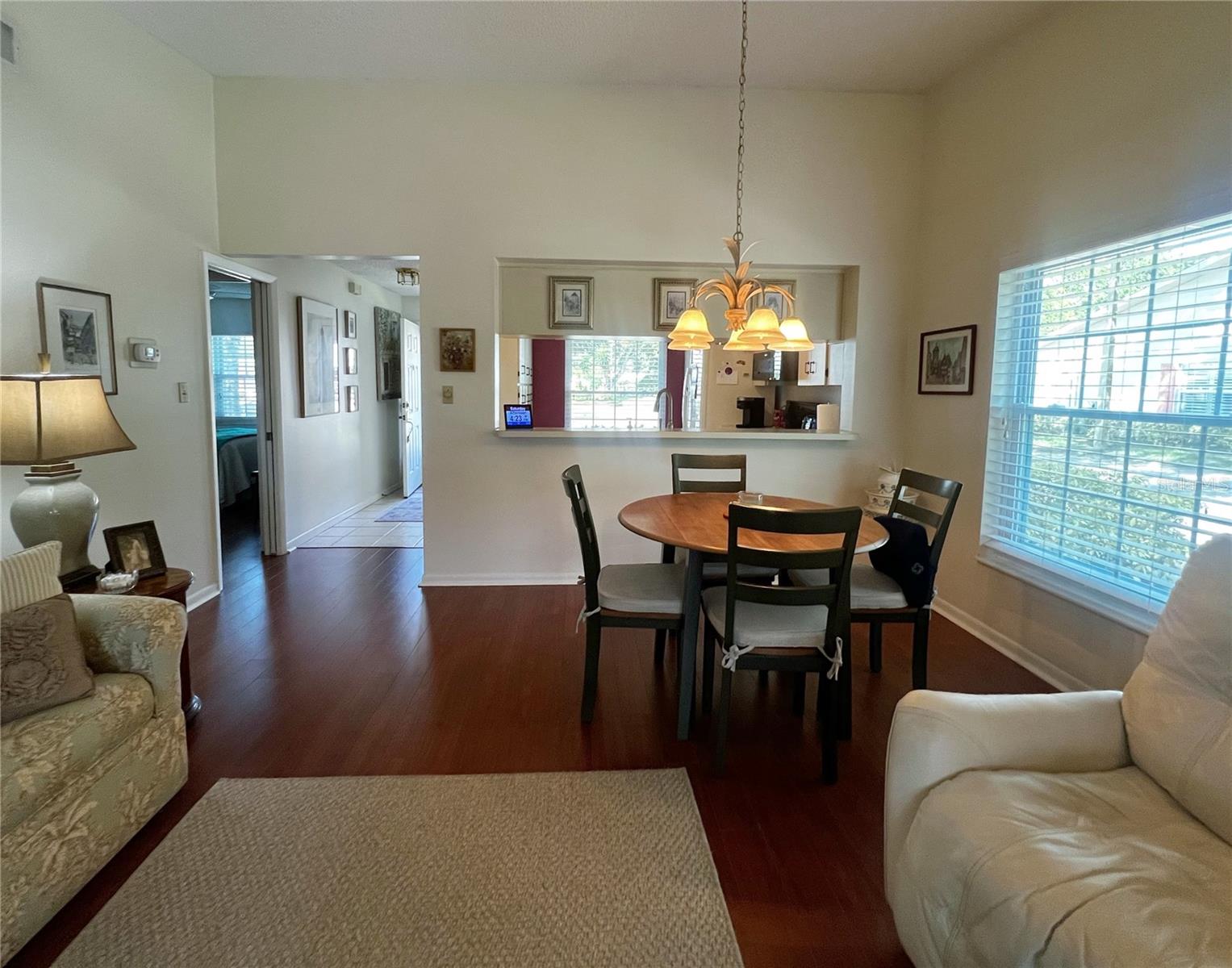 View of the living room and dining room looking towards the front entrance, kitchen, and guest bathroom and bedroom.