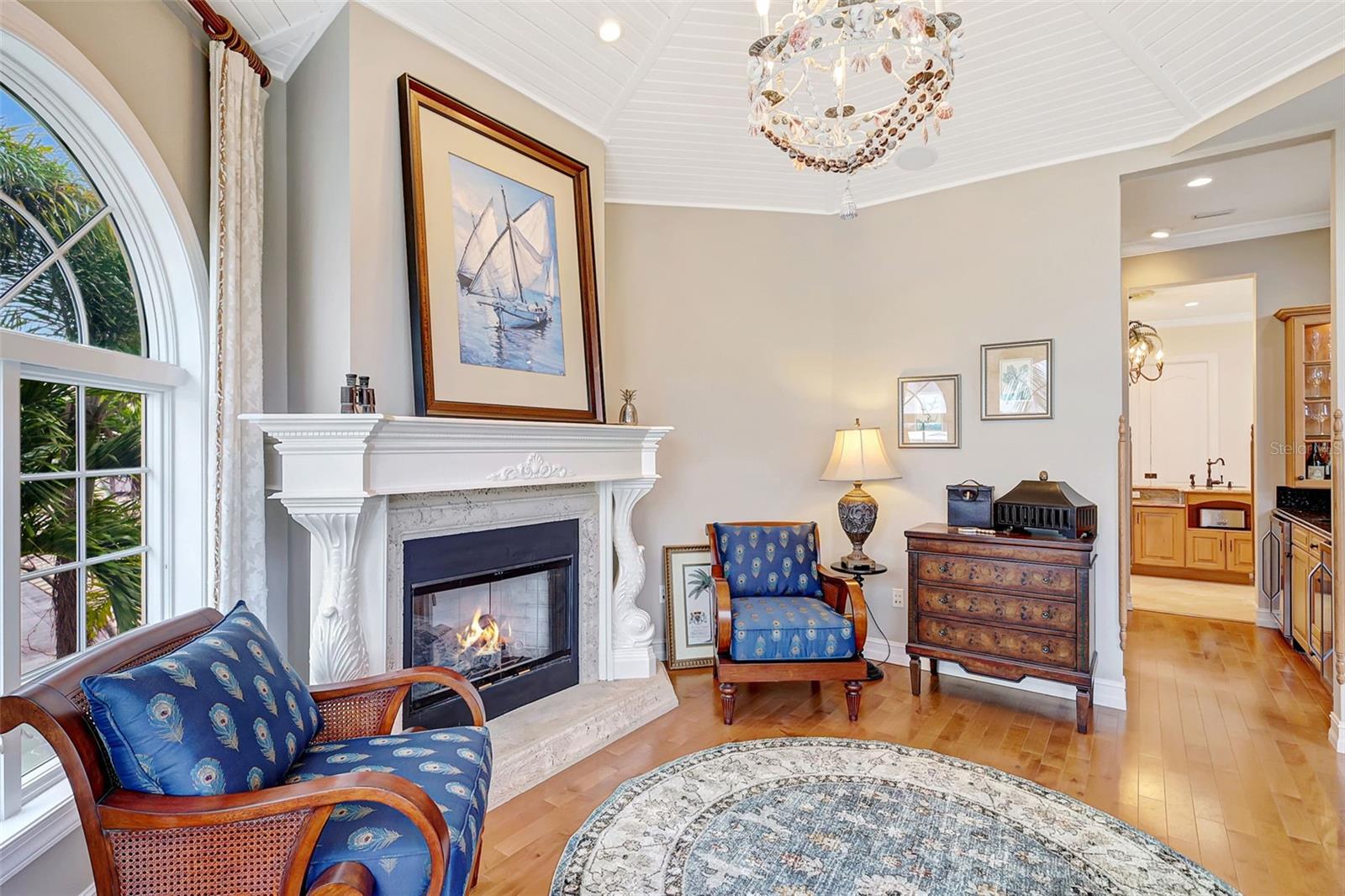 The Cozy, Round-Style Gathering Room Features Wood Floors, A Fireplace & Stunning Water Views!