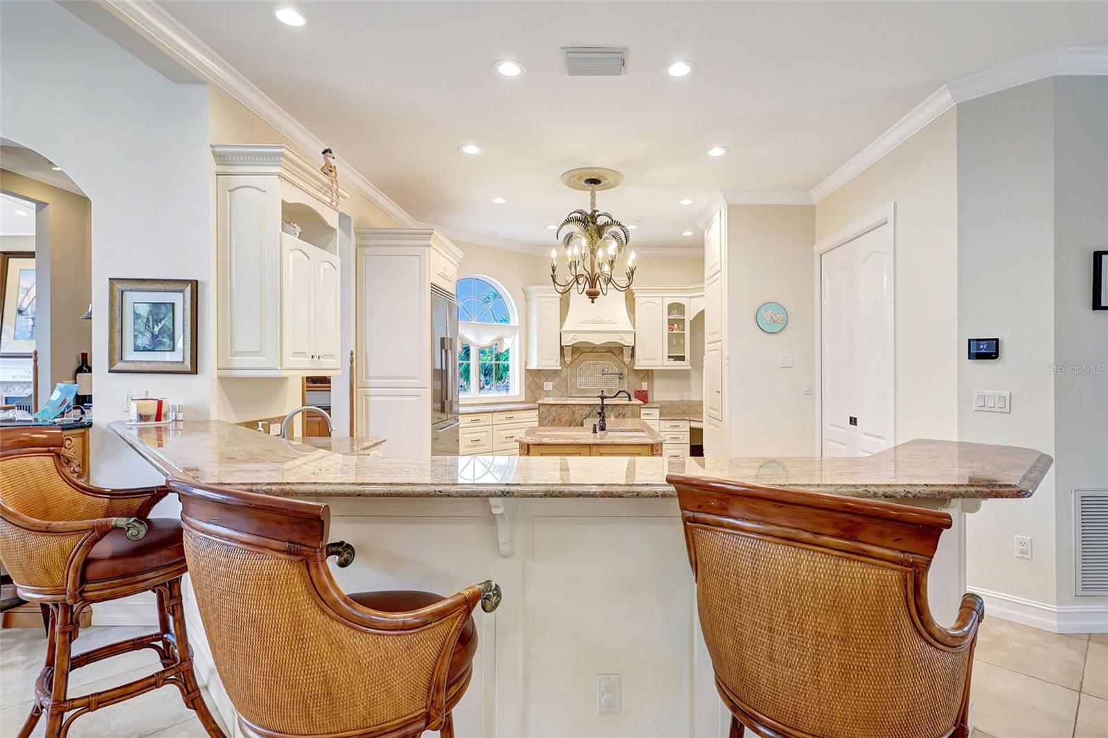 The Kitchen Boasts A Large Snack Bar With An Elegant Granite Counter.