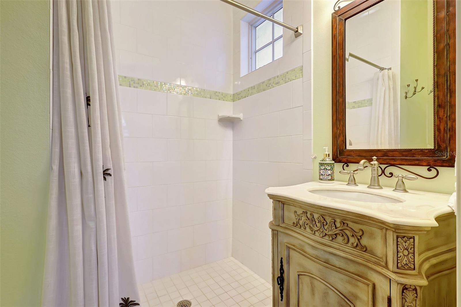 The Shower Features Elegant Tilework, Complemented By An Ornate Bathroom Vanity.