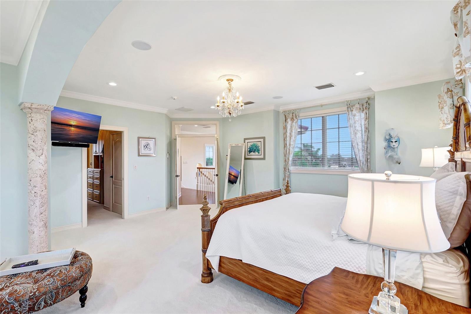 Elegant columns, soothing paint colors, and detailed crown molding come together to create a beautifully refined room.