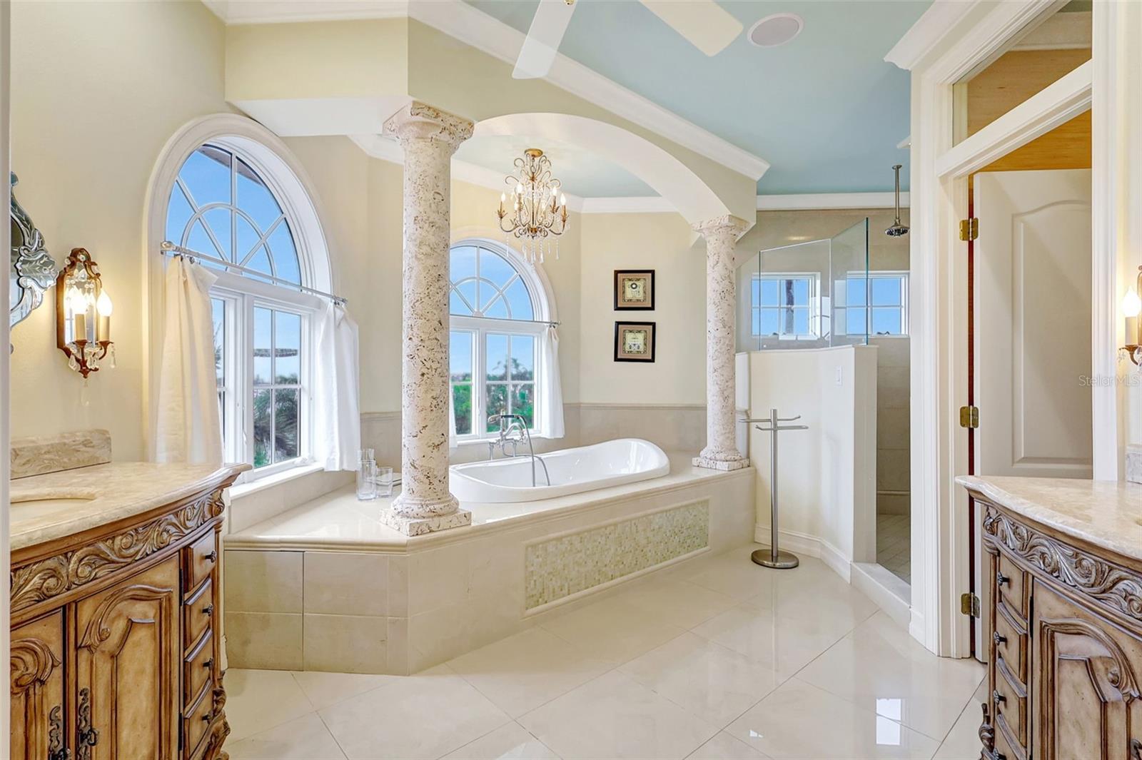 The private primary bathroom features dual vanities, a deep tub, large walk-in shower, water closet, and stunning water views.