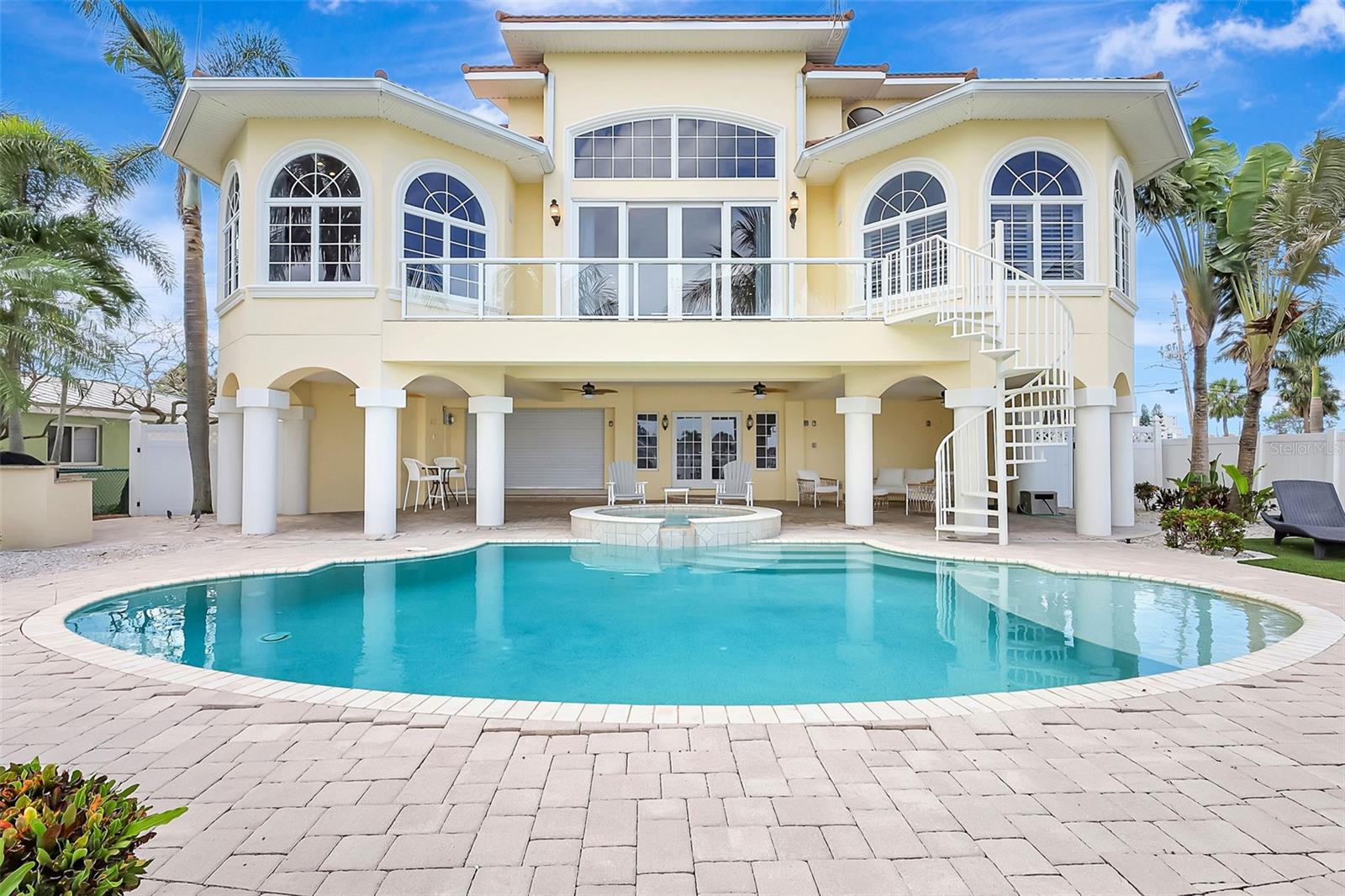 The outdoor pool and spillover spa are beautifully situated at the heart of the backyard, creating a stunning central focal point.