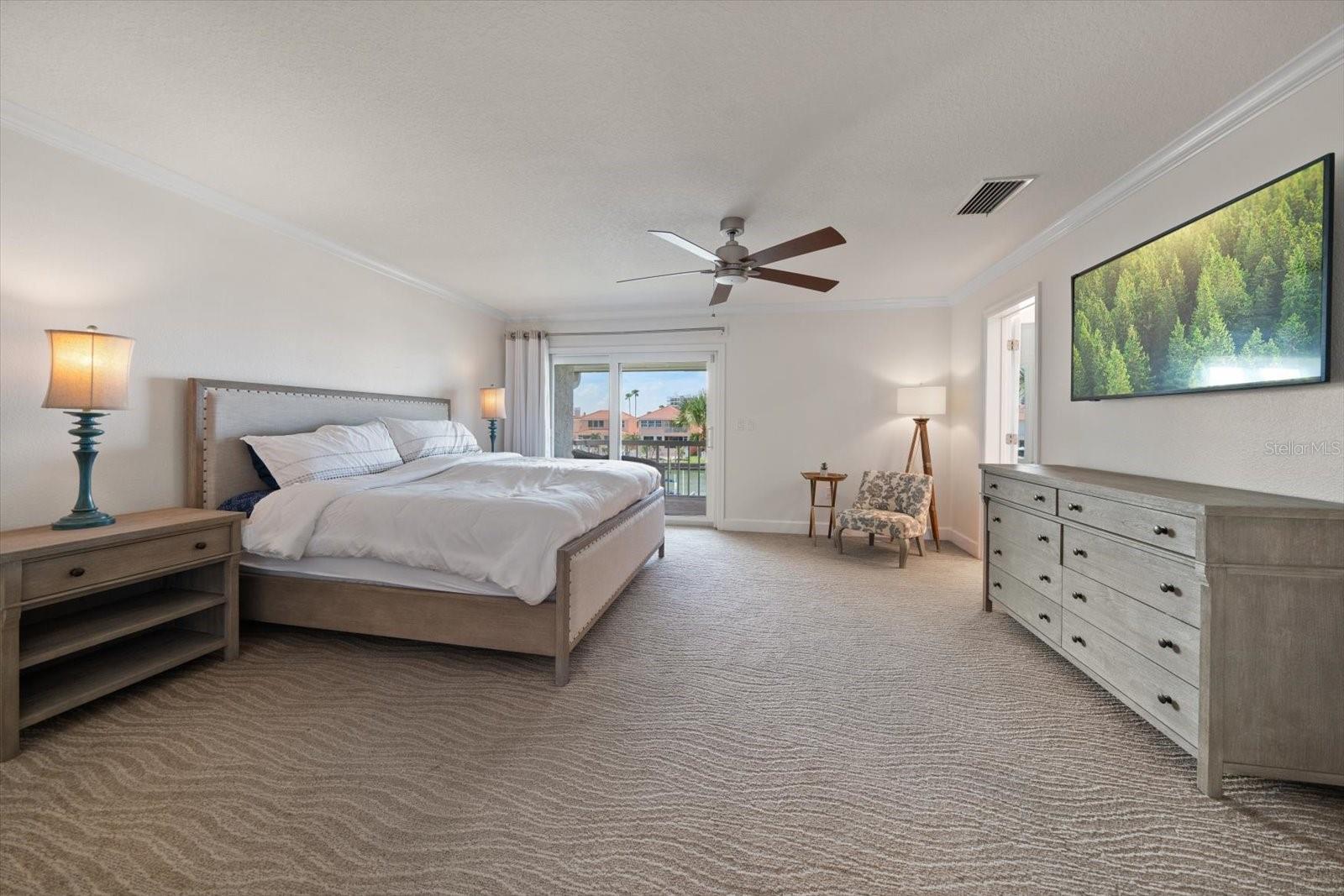 Primary suite is grand and offers private access to a balcony overlooking the canal.