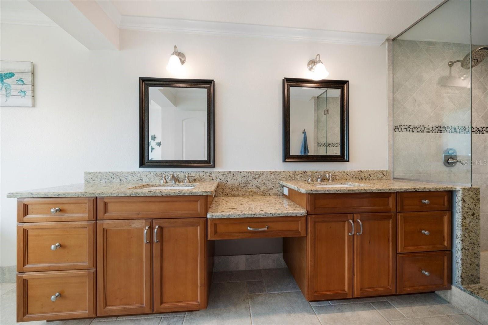 Primary bathroom has dual vanities, walk-in shower.