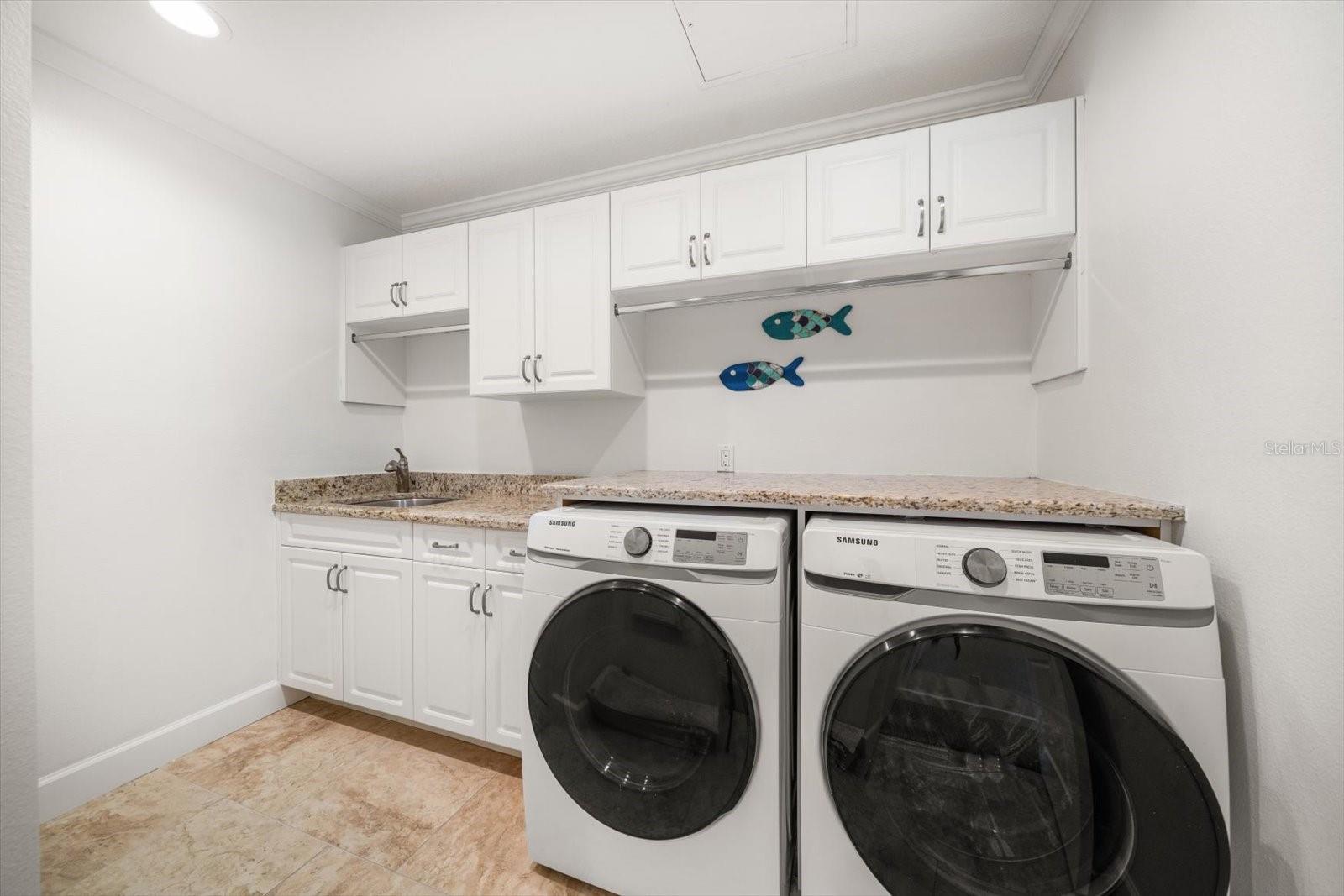 Laundry room with separate utility sink and storage.