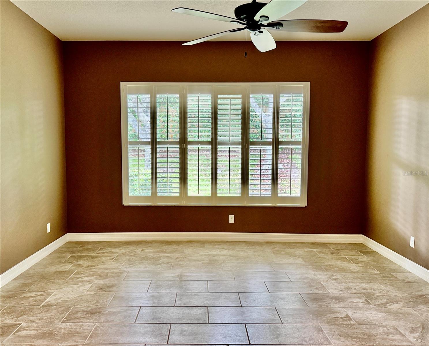 OWNER'S SUITE W/ PORCELAIN TILE FLOOR & PLANTATION SHUTTERS