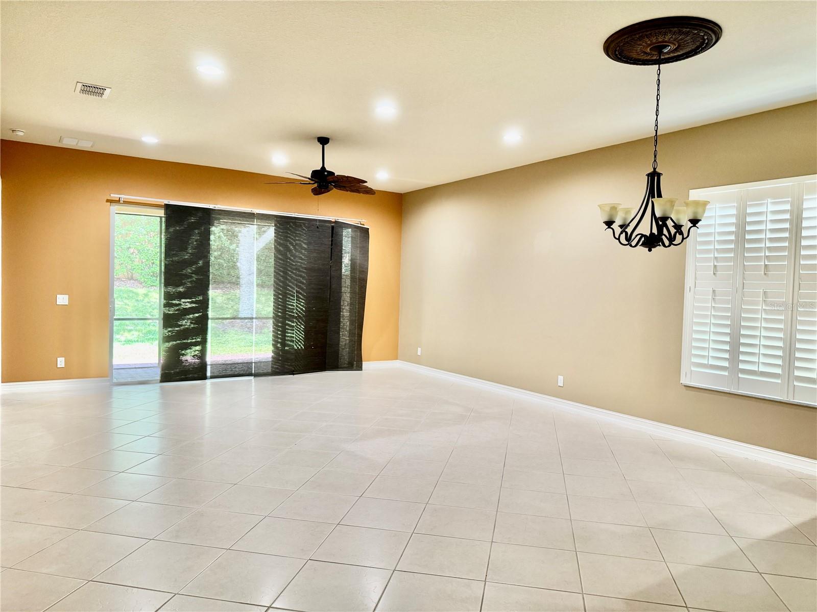 LIVING ROOM WITH LARGE TILE ON DIAGONAL & 3 DOOR SLIDER TO LANAI
