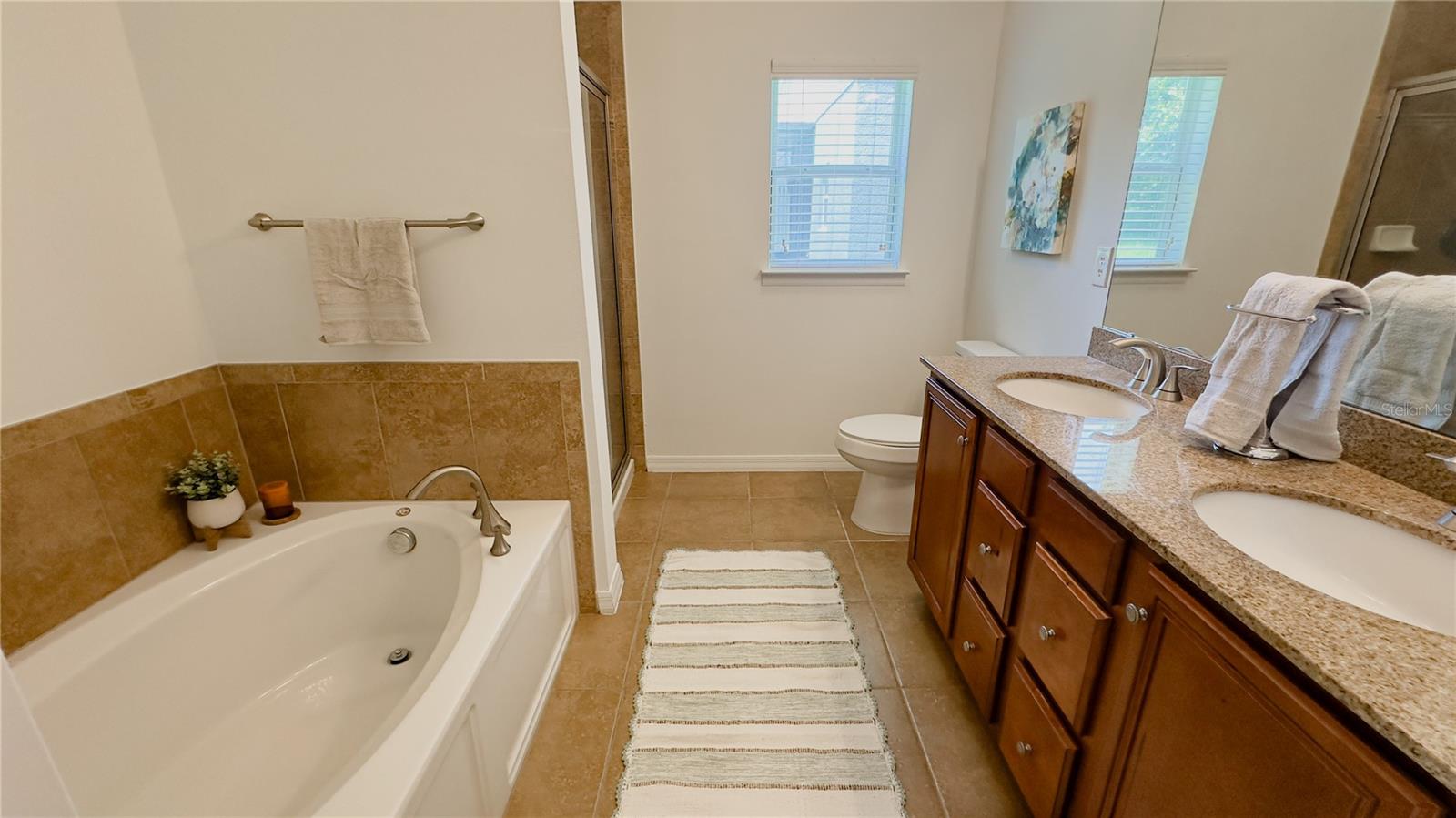 Ensuite master bath with granite counters, dual vanity, garden tub and tiled shower.