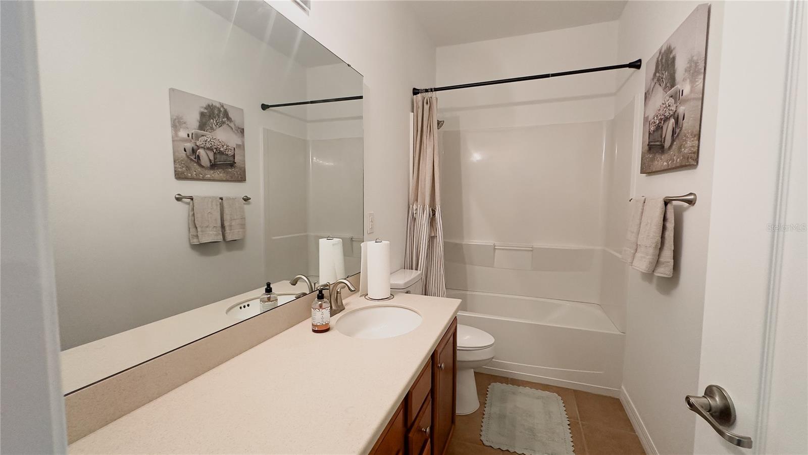 Guest bath with shower / tub combo and one piece tub surround