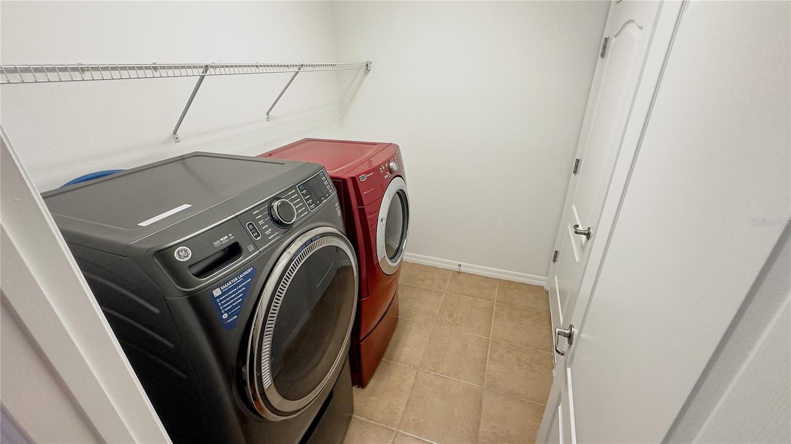 Inside laundry room. Sale includes the pedestal front loading washer and dryer. There is even a utility sink in here making it a perfect mud room off the garage.