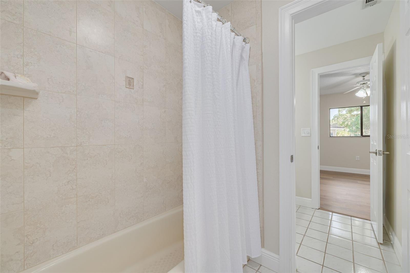 Tub and shower, flanked by private commode and sink for each of the guest bedrooms