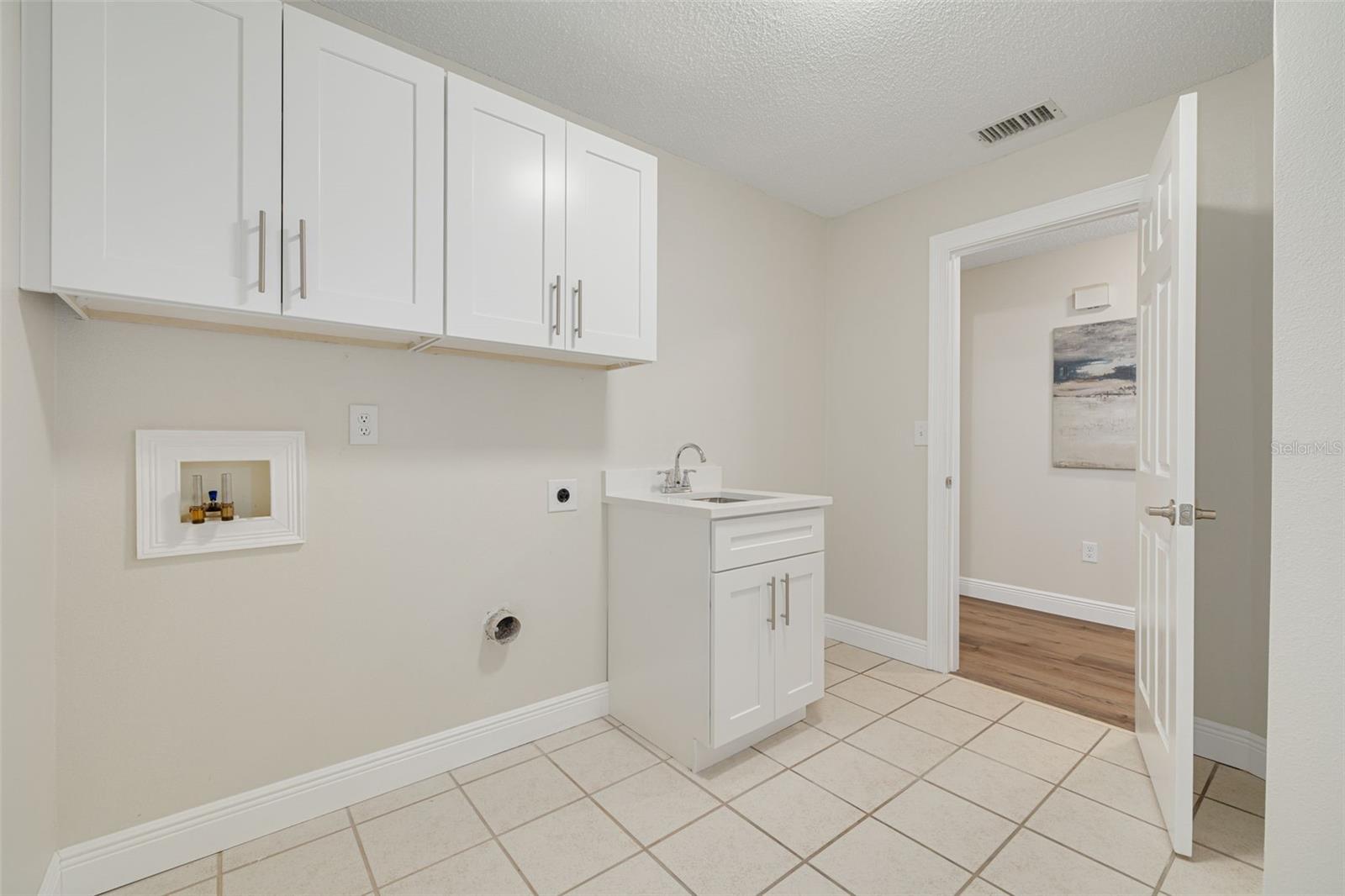Laundry room, with new cabinets and sink, ready for washer/dryer