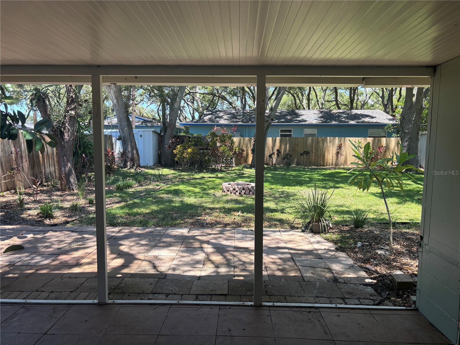 backyard view from covered back porch next to enclosed porch