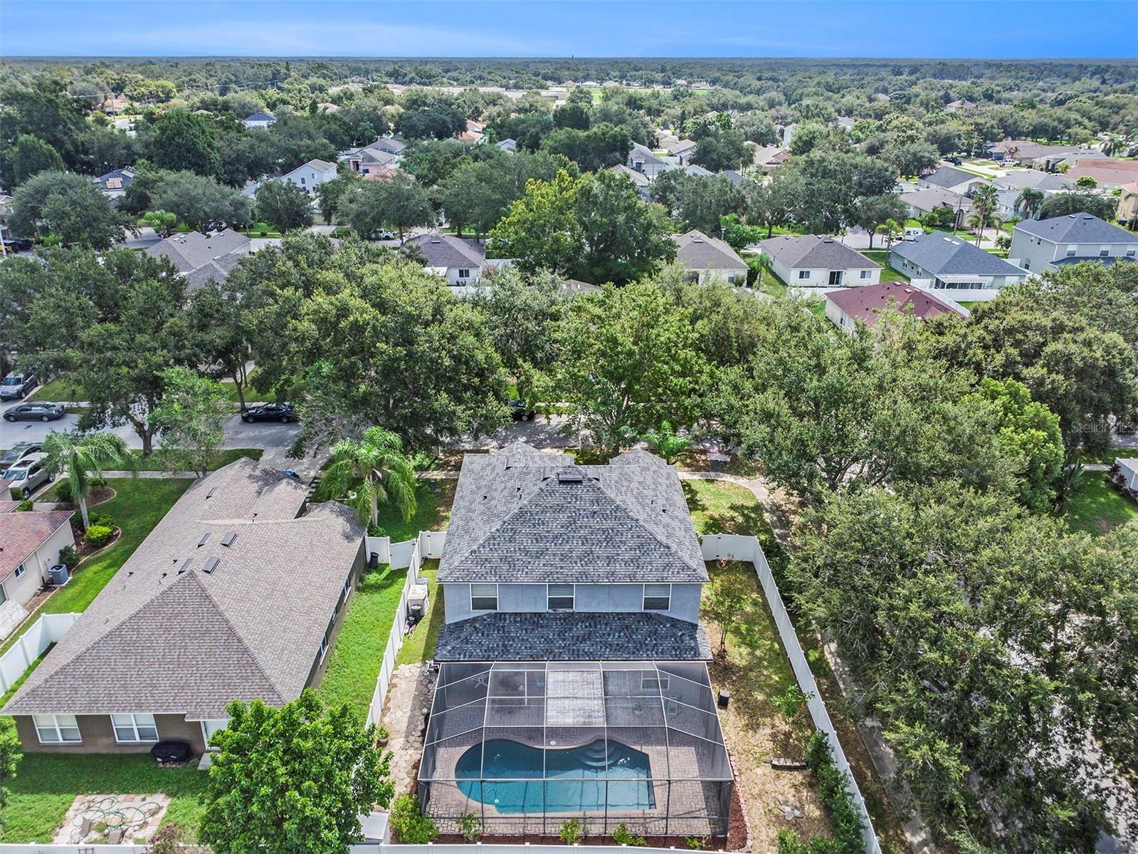 View of fenced lot and screened in ground pool